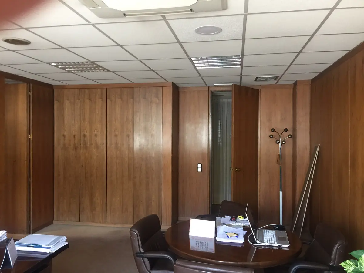Despacho con paneles de madera antes de la obra.